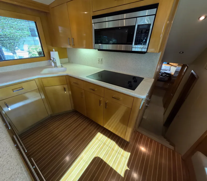 Slide: The Image of Luxurious kitchen in 2001 Hatteras 55 Convertible yacht with modern appliances and wood flooring. - 16