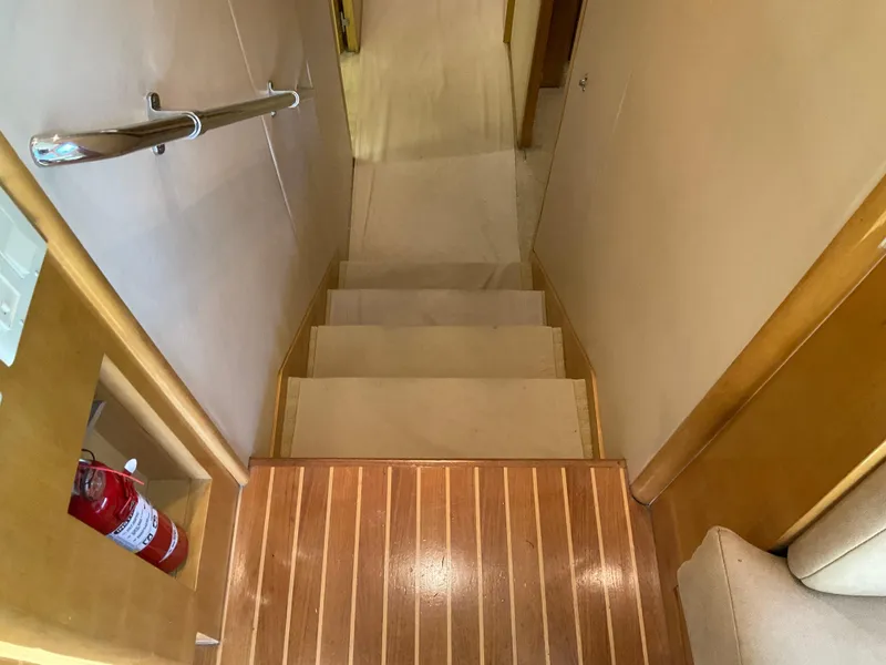 Slide: The Image of Staircase inside 2001 Hatteras 55 Convertible yacht with wooden steps and handrail. - 20