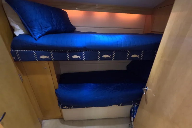 Slide: The Image of Bunk beds with blue bedding in a 2001 Hatteras 55 Convertible yacht cabin. - 30