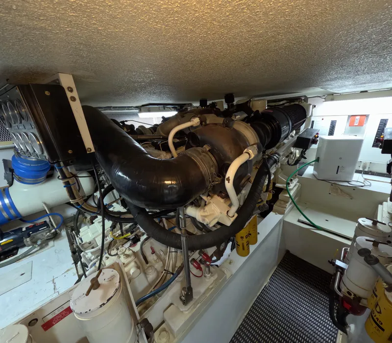 Slide: The Image of Engine room of a 2001 Hatteras 55 Convertible yacht, showcasing complex machinery and components. - 35