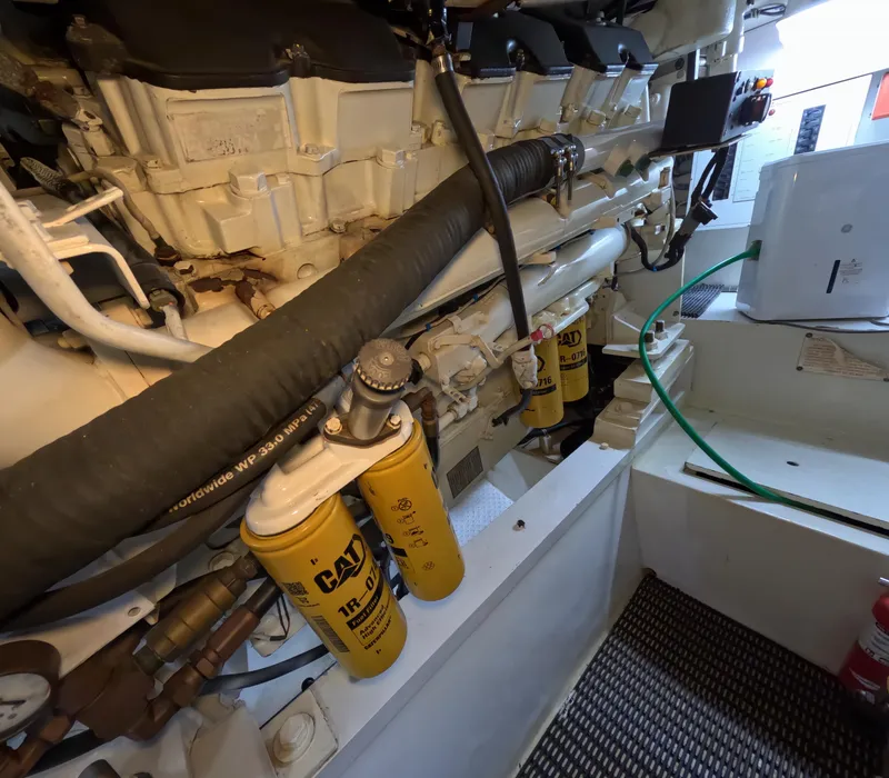 Slide: The Image of Engine room of 2001 Hatteras 55 Convertible yacht with CAT filters and hoses visible. - 36