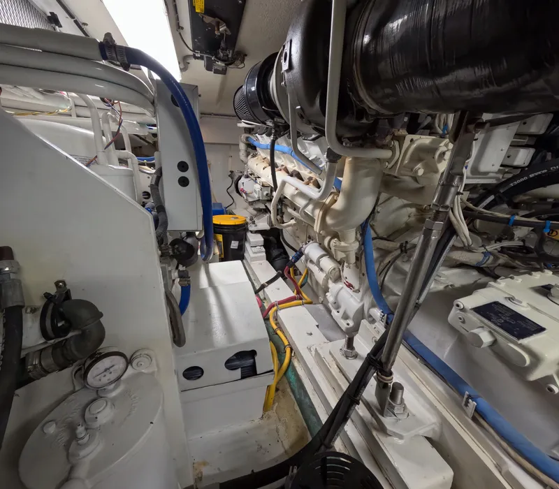 Slide: The Image of Engine room of 2001 Hatteras 55 Convertible yacht, showcasing mechanical components and piping. - 37