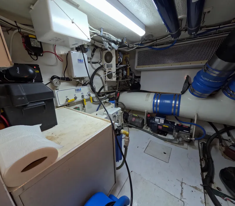 Slide: The Image of Engine room of a 2001 Hatteras 55 Convertible yacht, featuring mechanical equipment and piping. - 42
