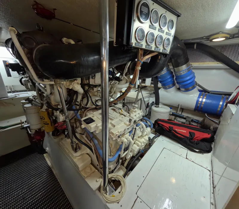 Slide: The Image of Engine room of 2001 Hatteras 55 Convertible yacht, featuring complex machinery and control panel. - 44