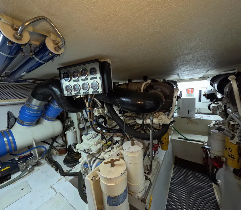 Slide: The Image of Engine room of 2001 Hatteras 55 Convertible yacht, showcasing complex machinery and gauges. - 46