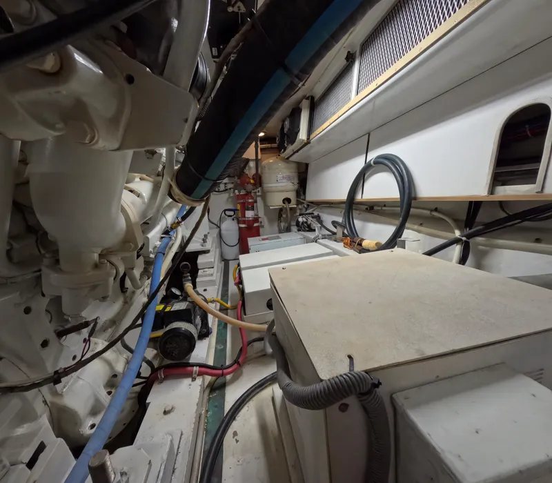Slide: The Image of Engine room of 2001 Hatteras 55 Convertible yacht, showcasing machinery and cables. - 47