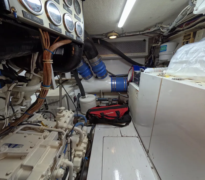 Slide: The Image of Engine room of a 2001 Hatteras 55 Convertible yacht, featuring gauges and mechanical components. - 48