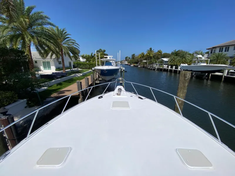 Slide: The Image of Bow view of 2001 Hatteras 55 Convertible yacht docked in a scenic canal. - 62