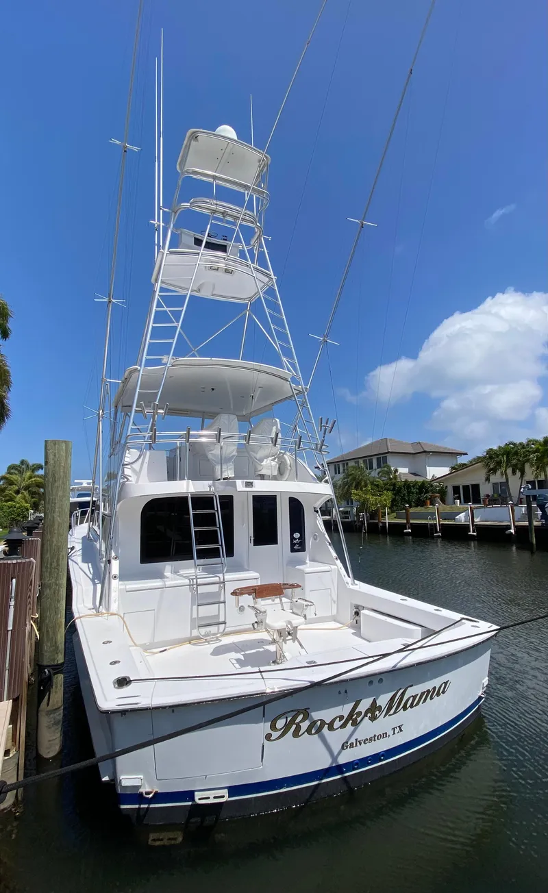 Slide: The Image of 2001 Hatteras 55 Convertible yacht docked in a marina under a clear blue sky. - 64