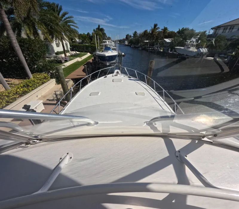 Slide: The Image of Bow view of 2001 Hatteras 55 Convertible yacht docked in a sunny canal. - 68
