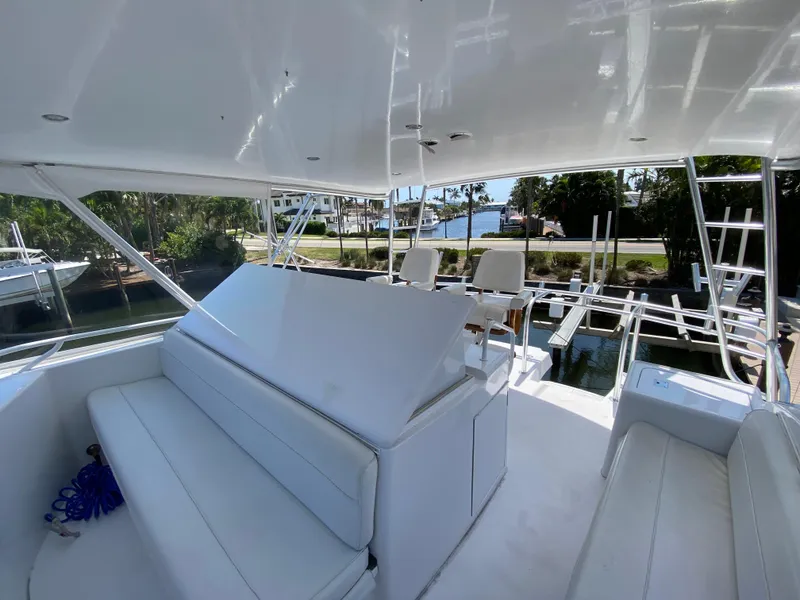 Slide: The Image of 2001 Hatteras 55 Convertible yacht interior with white seating and helm chairs. - 7
