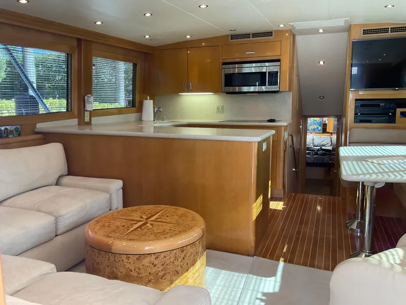 Slide: The Image of Luxurious interior of 2001 Hatteras 55 Convertible yacht with modern kitchen and seating area. - 9