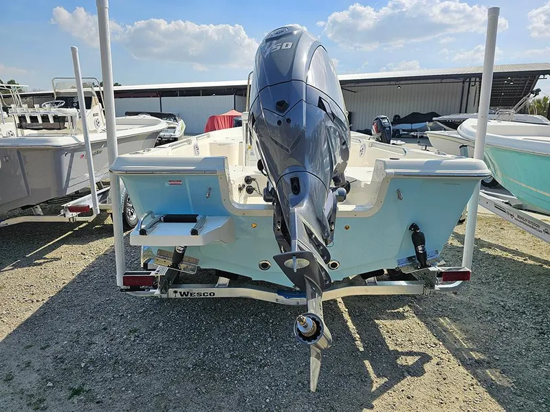 Slide: The Image of 2025 Bulls Bay 2000 boat with outboard motor, parked on a trailer in a marina. - 5