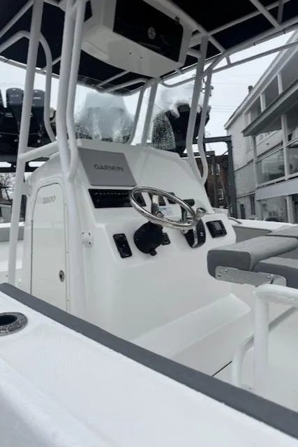 Slide: The Image of 2022 Aquasport 2100 Center Console boat interior with steering wheel and controls. - 10