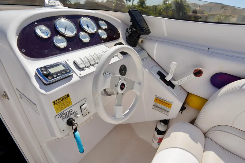 Slide: The Image of 1999 Donzi 26 ZX boat dashboard with steering wheel, gauges, and controls. - 10