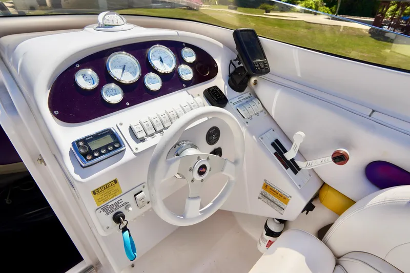 Slide: The Image of 1999 Donzi 26 ZX boat cockpit with steering wheel, gauges, and controls. - 11