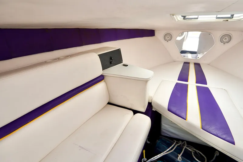 Slide: The Image of 1999 Donzi 26 ZX cabin interior with white and purple seating and modern design. - 16