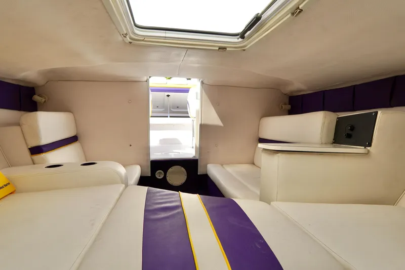 Slide: The Image of 1999 Donzi 26 ZX cabin interior with white and purple seating, skylight, and modern design. - 18