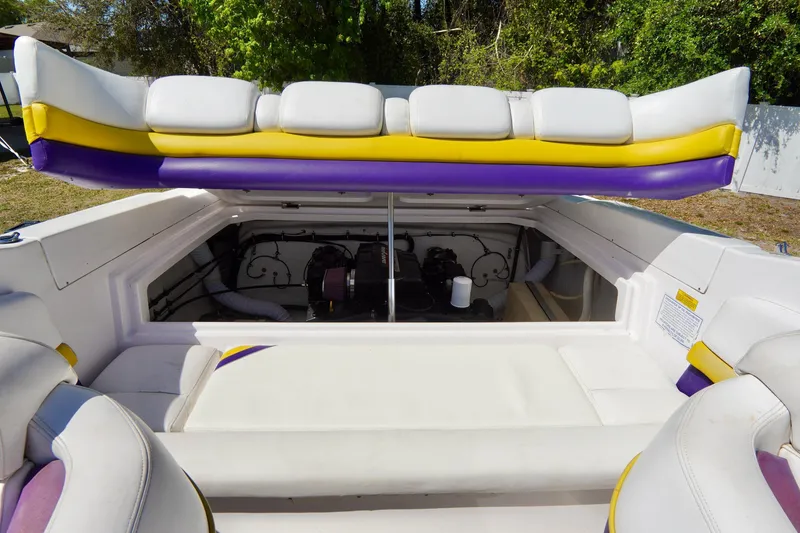 Slide: The Image of 1999 Donzi 26 ZX boat interior with open engine compartment, featuring white and purple seating. - 21