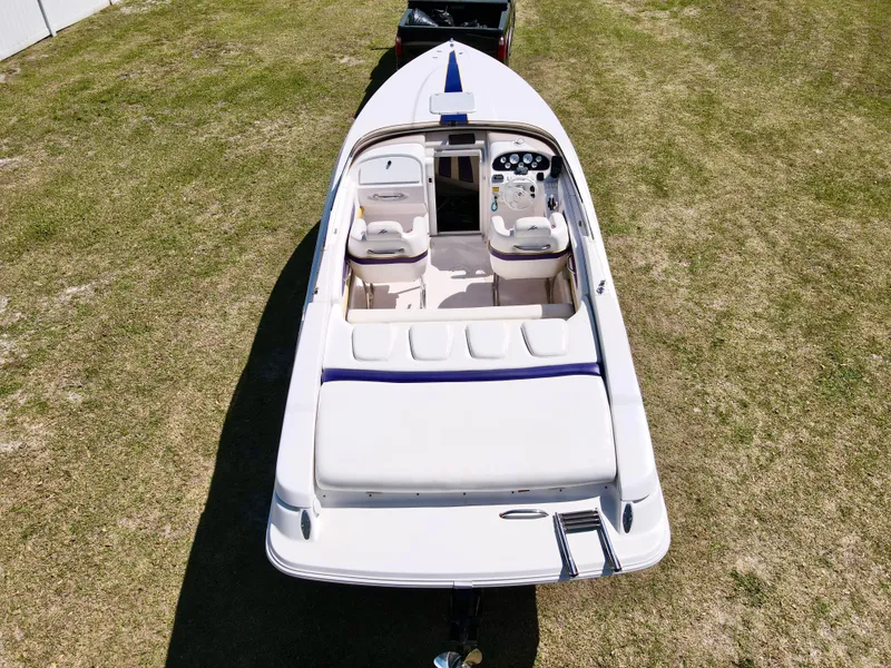 Slide: The Image of 1999 Donzi 26 ZX boat on grass, aerial view, showcasing cockpit and seating. - 27