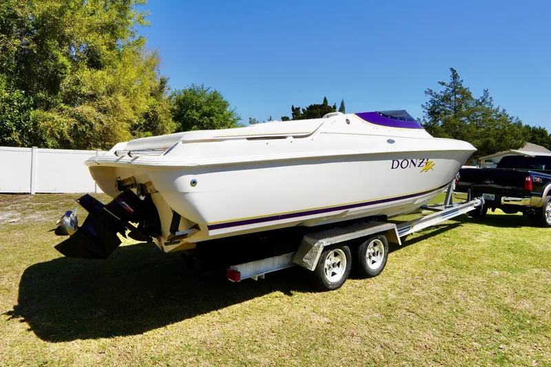 Slide: The Image of 1999 Donzi 26 ZX boat on trailer, parked on grass, sunny day. - 29