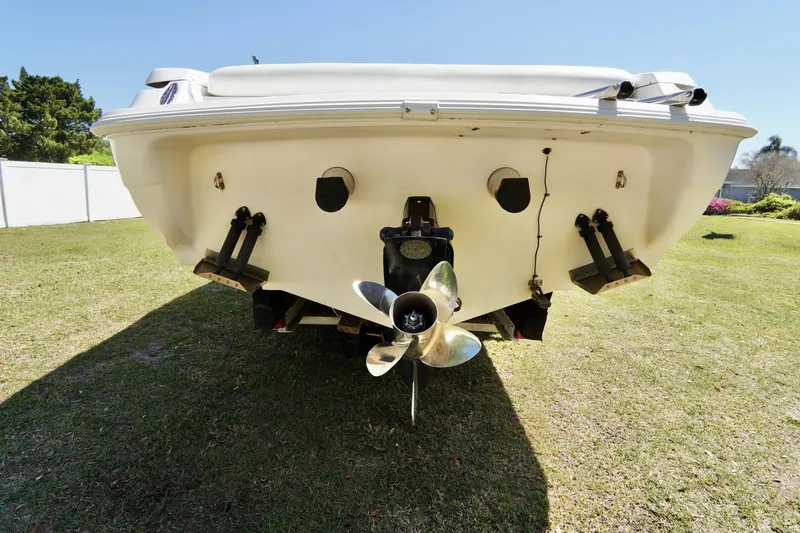 Slide: The Image of Rear view of a 1999 Donzi 26 ZX boat on grass, showing propeller and hull details. - 30