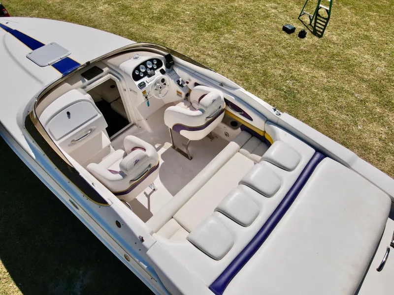 Slide: The Image of 1999 Donzi 26 ZX boat interior with white seating and dashboard, viewed from above. - 9