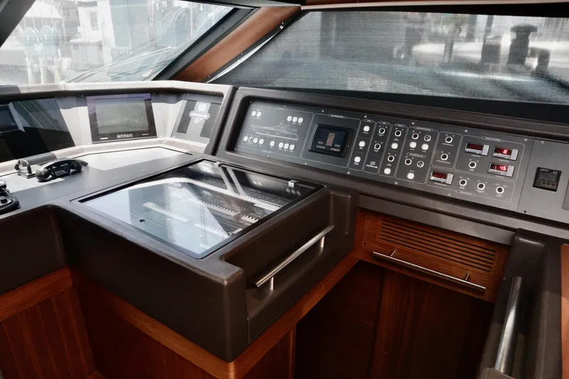 Slide: The Image of Helm station of 2016 Custom Line 97 yacht with modern navigation controls and wood finish. - 16
