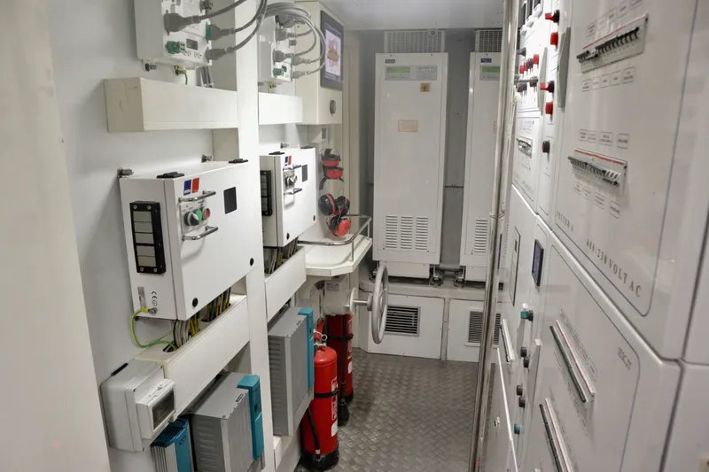 Slide: The Image of Electrical control room inside a 2016 Custom Line 97 yacht, featuring panels and safety equipment. - 30