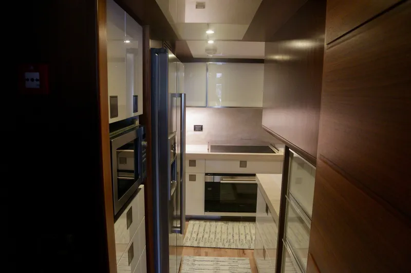 Slide: The Image of Modern kitchen interior on 2016 Custom Line 97 yacht, featuring sleek cabinetry and appliances. - 14