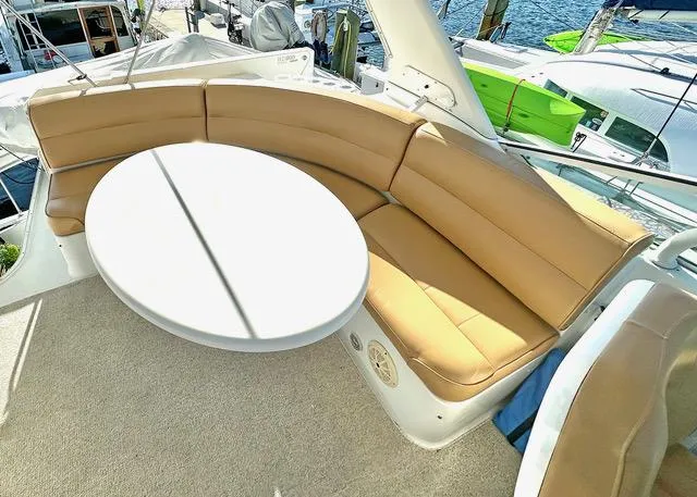 Slide: The Image of 1999 Carver 450 Voyager Pilothouse yacht with tan seating and round table on deck. - 6