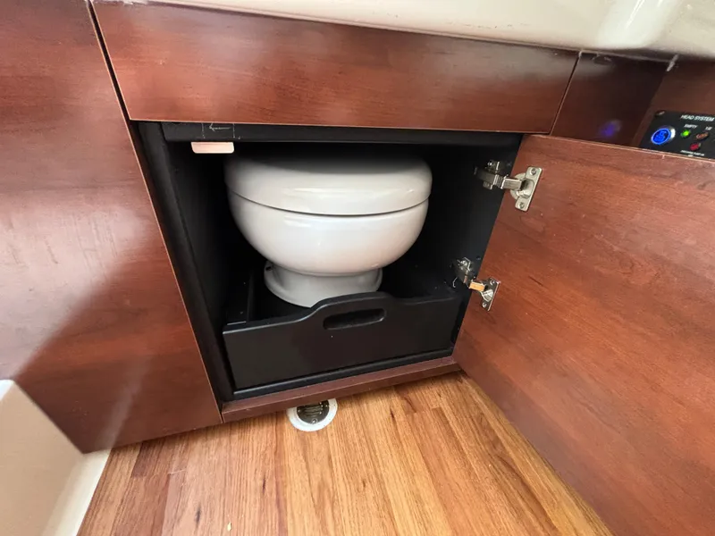 Slide: The Image of 2021 Chaparral 300 OSX boat interior with hidden toilet compartment. - 11