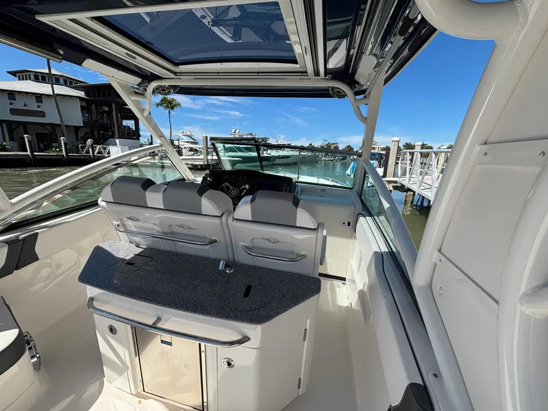 Slide: The Image of 2021 Chaparral 300 OSX boat interior with seating and helm, docked at marina. - 5