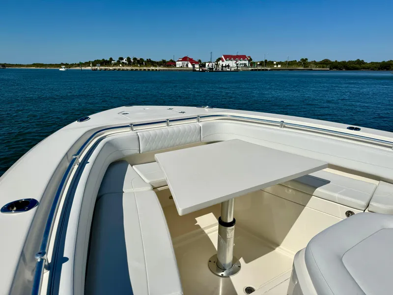 Slide: The Image of 2020 Cobia 350 Center Console boat with table, scenic waterfront view. - 18