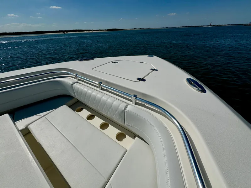 Slide: The Image of Cobia 350 Center Console 2020 boat on calm water, featuring spacious seating area. - 22