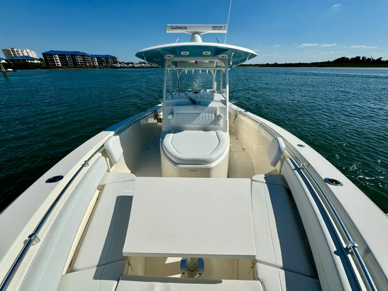 Slide: The Image of 2020 Cobia 350 Center Console boat on calm water, featuring spacious deck and seating. - 24
