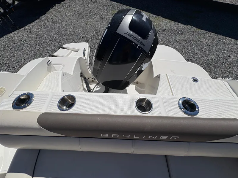 Slide: The Image of 2019 Bayliner 210 Deck Boat with Mercury engine, featuring cup holders and seating area. - 12