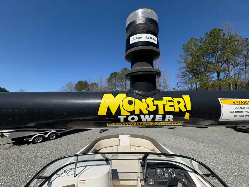 Slide: The Image of 2019 Bayliner 210 Deck Boat with Monster Tower wakeboard accessory, parked outdoors. - 17