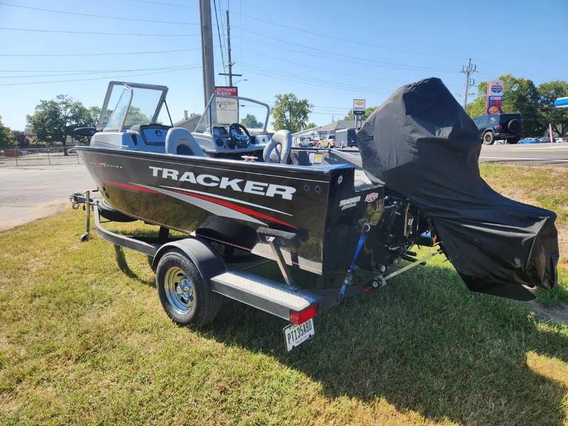 Slide: The Image of 2019 Tracker Pro V 175 Guide boat on trailer, parked on grass, with engine cover. - 2