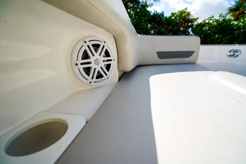 Slide: The Image of 2021 Hurricane SunDeck 235 OB interior with speaker and cup holder, showcasing luxury features. - 13