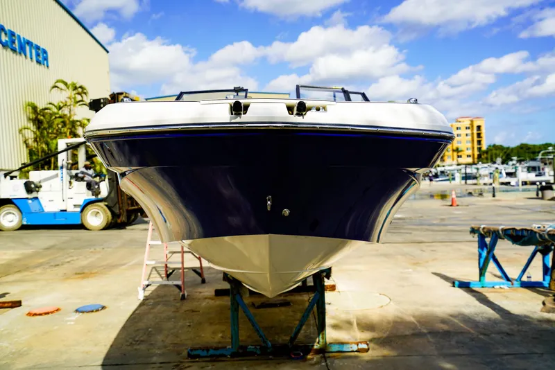 Slide: The Image of 2021 Hurricane SunDeck 235 OB boat on stand, marina background, sunny day. - 17