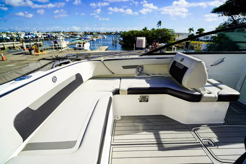 Slide: The Image of 2021 Hurricane SunDeck 235 OB boat interior with seating, docked at marina under blue sky. - 4