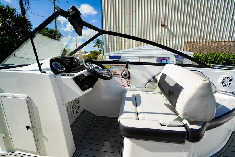 Slide: The Image of 2021 Hurricane SunDeck 235 OB boat interior with steering wheel and seating. - 7