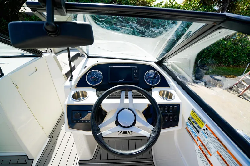 Slide: The Image of 2021 Hurricane SunDeck 235 OB boat cockpit with steering wheel and dashboard controls. - 8