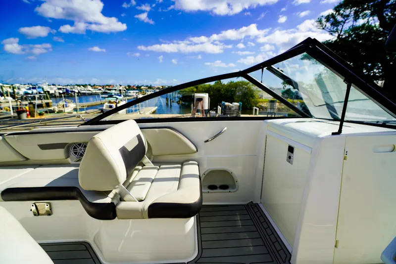 Slide: The Image of 2021 Hurricane SunDeck 235 OB boat interior with seating, docked at marina under blue sky. - 9