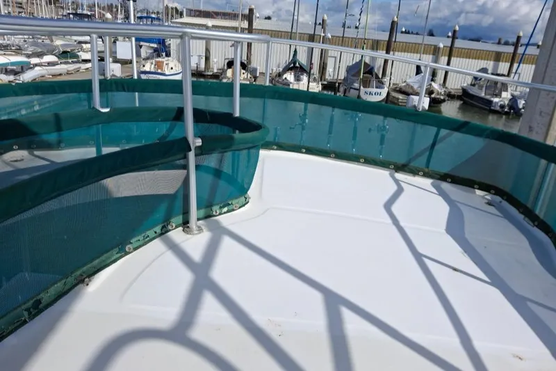 Slide: The Image of Deck view of 1997 Mainship 350 yacht with green railing, docked at marina. - 10