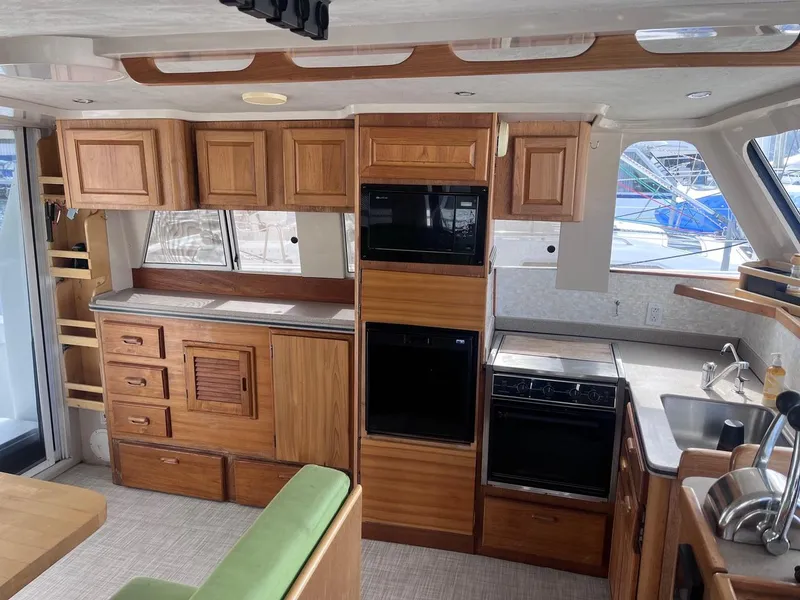 Slide: The Image of Interior of 1997 Mainship 350 yacht with wooden cabinetry and modern kitchen amenities. - 18
