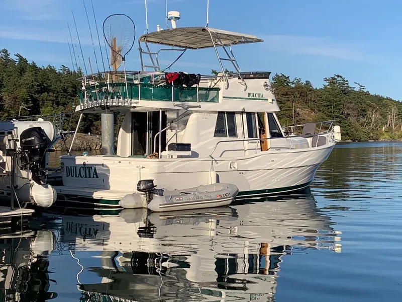 Slide: The Image of 1997 Mainship 350 yacht docked on calm water with fishing gear. - 2