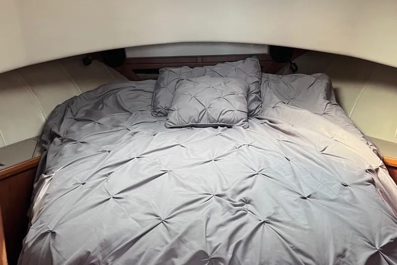 Slide: The Image of Cozy cabin bed in 1997 Mainship 350 yacht with gray bedding and pillows. - 22