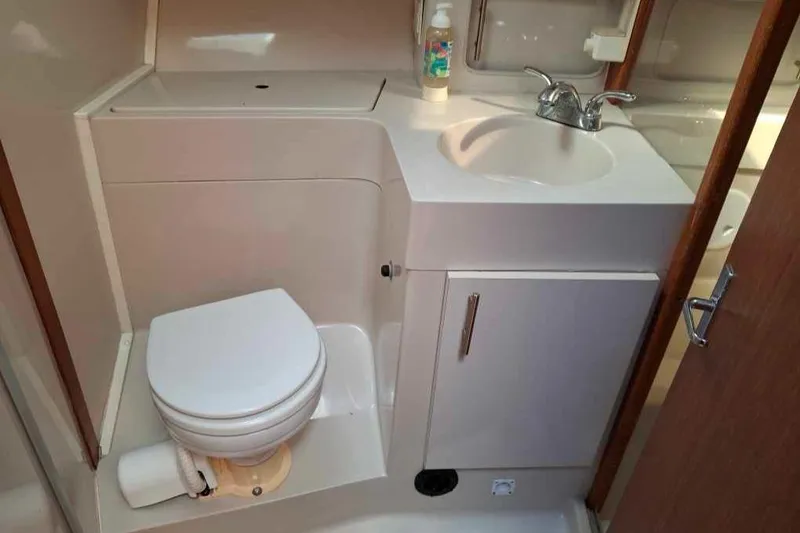 Slide: The Image of 1997 Mainship 350 yacht bathroom with toilet, sink, and cabinet. - 23